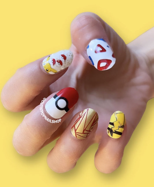 This image displays Cutie Pop Nail Shop's latest custom Pokémon nail wraps featuring Pikachu and Gotta Catch 'Em All designs.