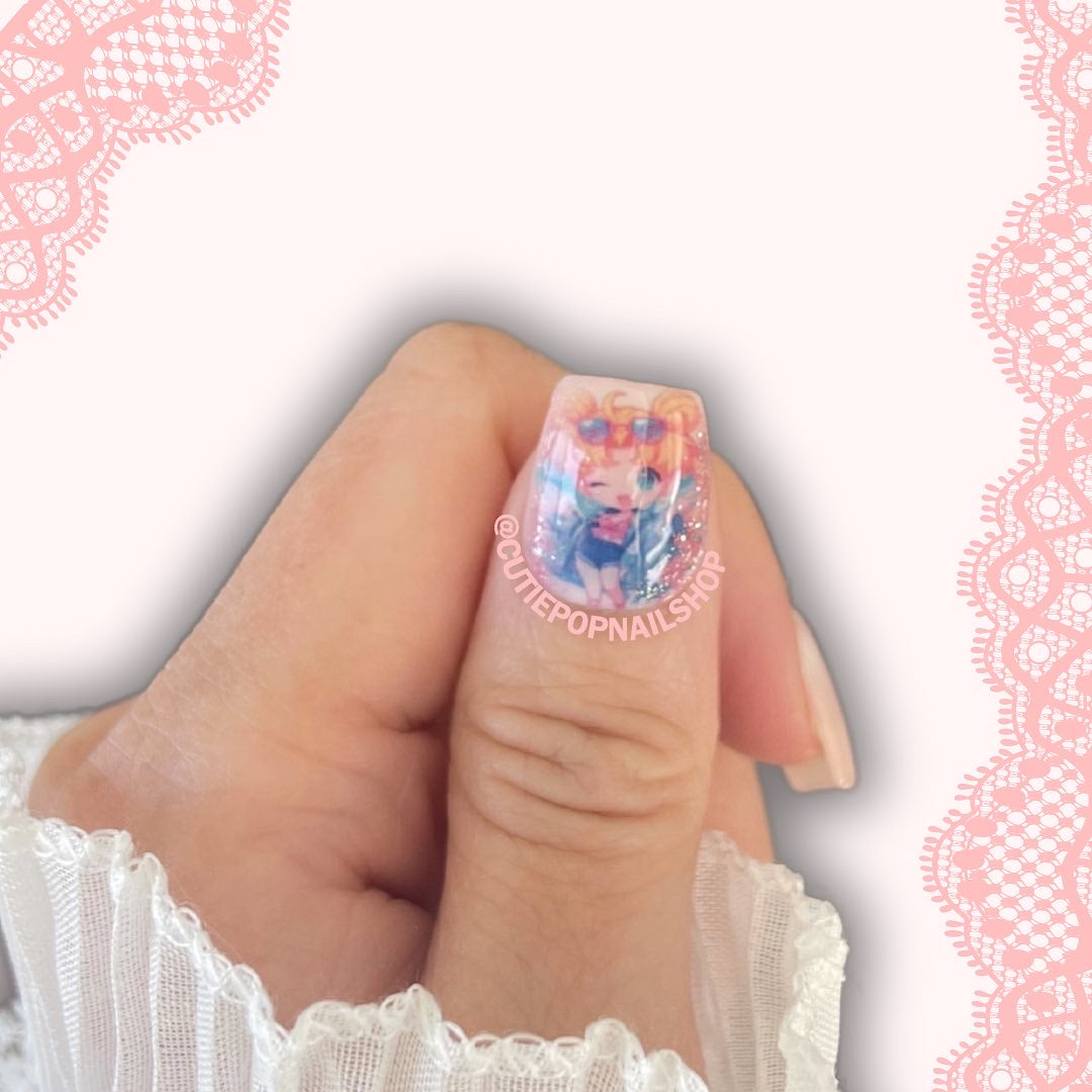 Moon Prism press‑on nails by CutiePop Nail Shop featuring medium-length square-shaped nails with a sheer, pastel pink-to-lavender jelly gradient and iridescent holographic sparkle. Accented with delicate hand‑placed star glitter, tiny crescent moon charms, and subtle metallic flake shimmer—delivering a dreamy, celestial-inspired manicure perfect for magical girl or Y2K aesthetic lovers. Kit includes ten reusable nails, adhesive tab sheet, a mini nail file, and a cuticle stick.