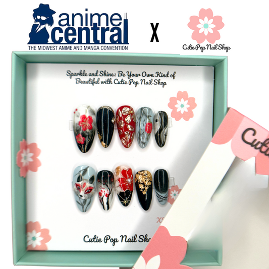 Anime Central – Kitsune press on nails by CutiePop Nail Shop featuring medium round shaped nails with anime-inspired fox art and red floral accents. This design blends traditional Japanese kitsune motifs with modern nail aesthetics for a bold and mystical look.