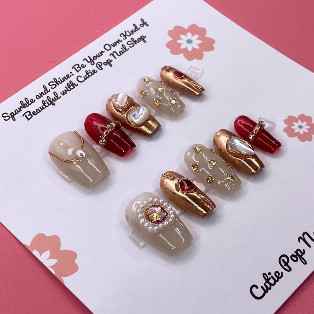 Cleopatra press on nails by CutiePop Nail Shop featuring medium coffin shaped nails in bold gold and black tones with Egyptian-inspired patterns, metallic accents, and a regal, luxurious vibe.