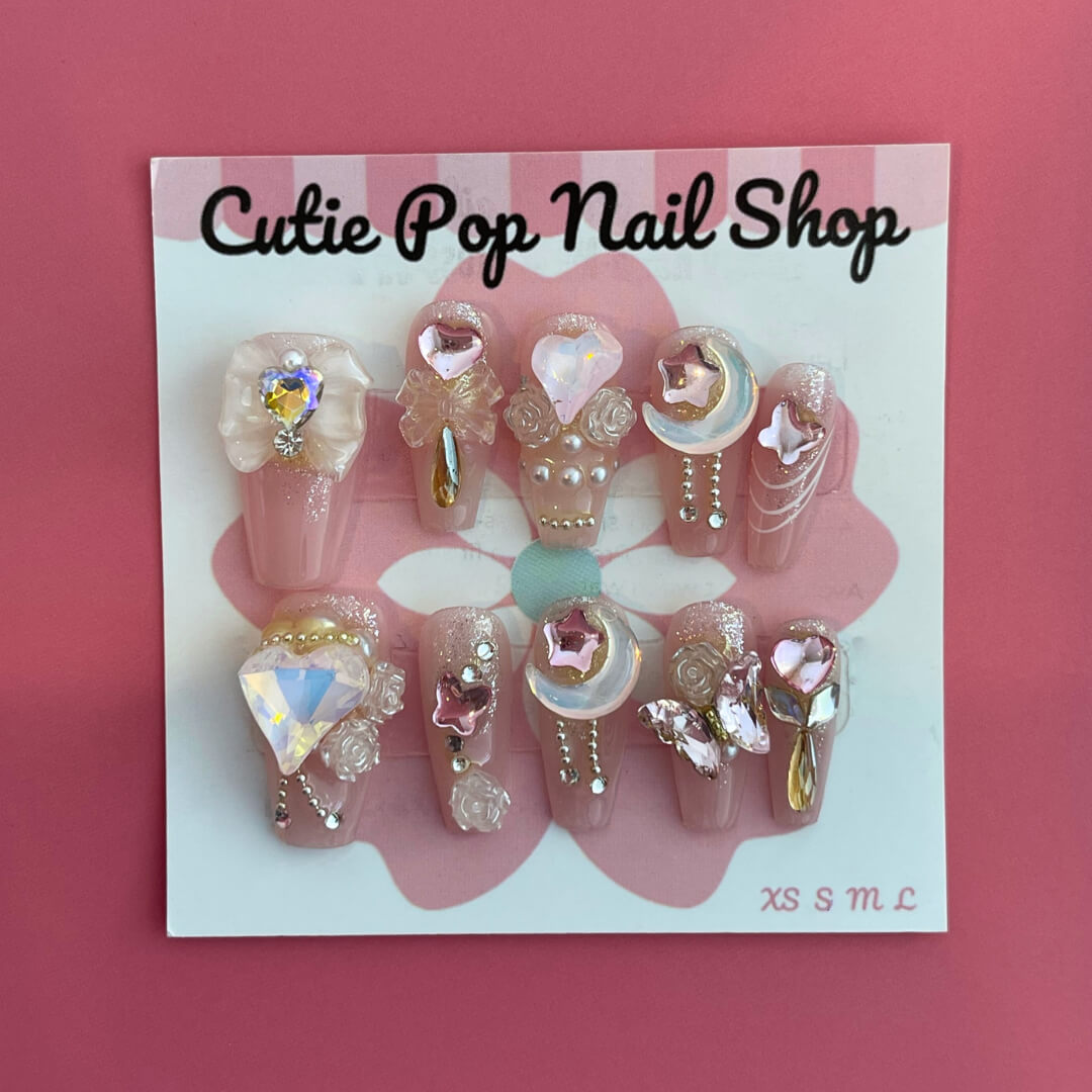 Dream Girl press‑on nails by CutiePop Nail Shop featuring short-to-medium length round or oval nails in a soft pastel palette of blush pink, lavender, mint green, and creamy white. Decorated with dreamy motifs like iridescent stars, floating hearts, subtle floral accents, and holographic shimmer. Includes adhesive tabs, mini nail file, and cuticle stick for DIY application—delivering a whimsical, youthful aesthetic perfect for pastel dreams.