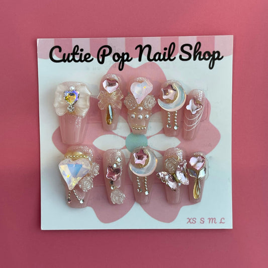Dream Girl press‑on nails by CutiePop Nail Shop featuring short-to-medium length round or oval nails in a soft pastel palette of blush pink, lavender, mint green, and creamy white. Decorated with dreamy motifs like iridescent stars, floating hearts, subtle floral accents, and holographic shimmer. Includes adhesive tabs, mini nail file, and cuticle stick for DIY application—delivering a whimsical, youthful aesthetic perfect for pastel dreams.