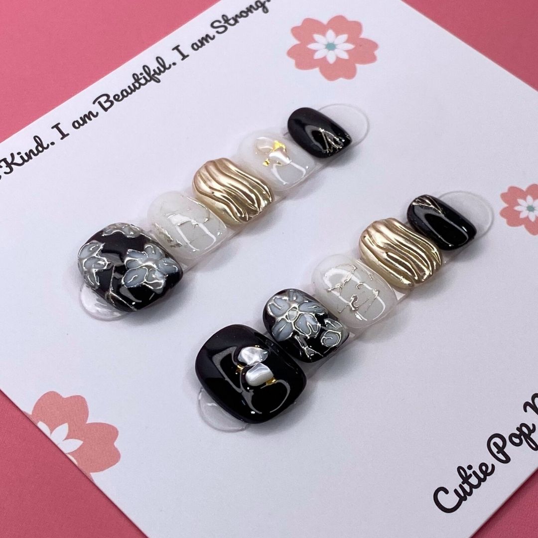Flower Gem press-on nails by CutiePop Nail Shop featuring short-length squoval-shaped nails in soft pastel tones. Embellished with intricate 3D floral designs and sparkling gem accents, these nails offer a delicate and elegant aesthetic perfect for springtime charm or everyday beauty. Includes 10 reusable handmade nails, jelly adhesive tabs, a mini nail file, and a cuticle stick for effortless application.