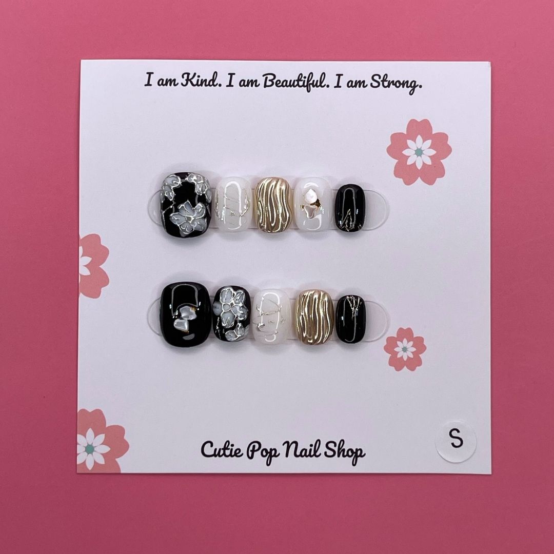Flower Gem press-on nails by CutiePop Nail Shop featuring short-length squoval-shaped nails in soft pastel tones. Embellished with intricate 3D floral designs and sparkling gem accents, these nails offer a delicate and elegant aesthetic perfect for springtime charm or everyday beauty. Includes 10 reusable handmade nails, jelly adhesive tabs, a mini nail file, and a cuticle stick for effortless application.