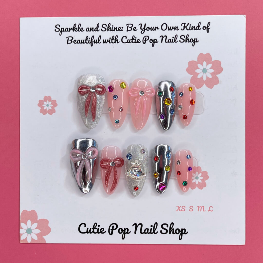 Gem Princess press-on nails by CutiePop Nail Shop featuring a creamy blush-pink base with ultra-fine shimmer, hand-placed pastel gem clusters, and clear rhinestones. Select nails are accented with tiny pearls or heart motifs for added charm. Crafted in a medium-length almond shape with a glossy gel finish, this design brings an elegant and whimsical princess-like aesthetic to your manicure. Each set includes 10 reusable handmade nails, jelly adhesive tabs, a mini nail file, and a cuticle stick for effortles