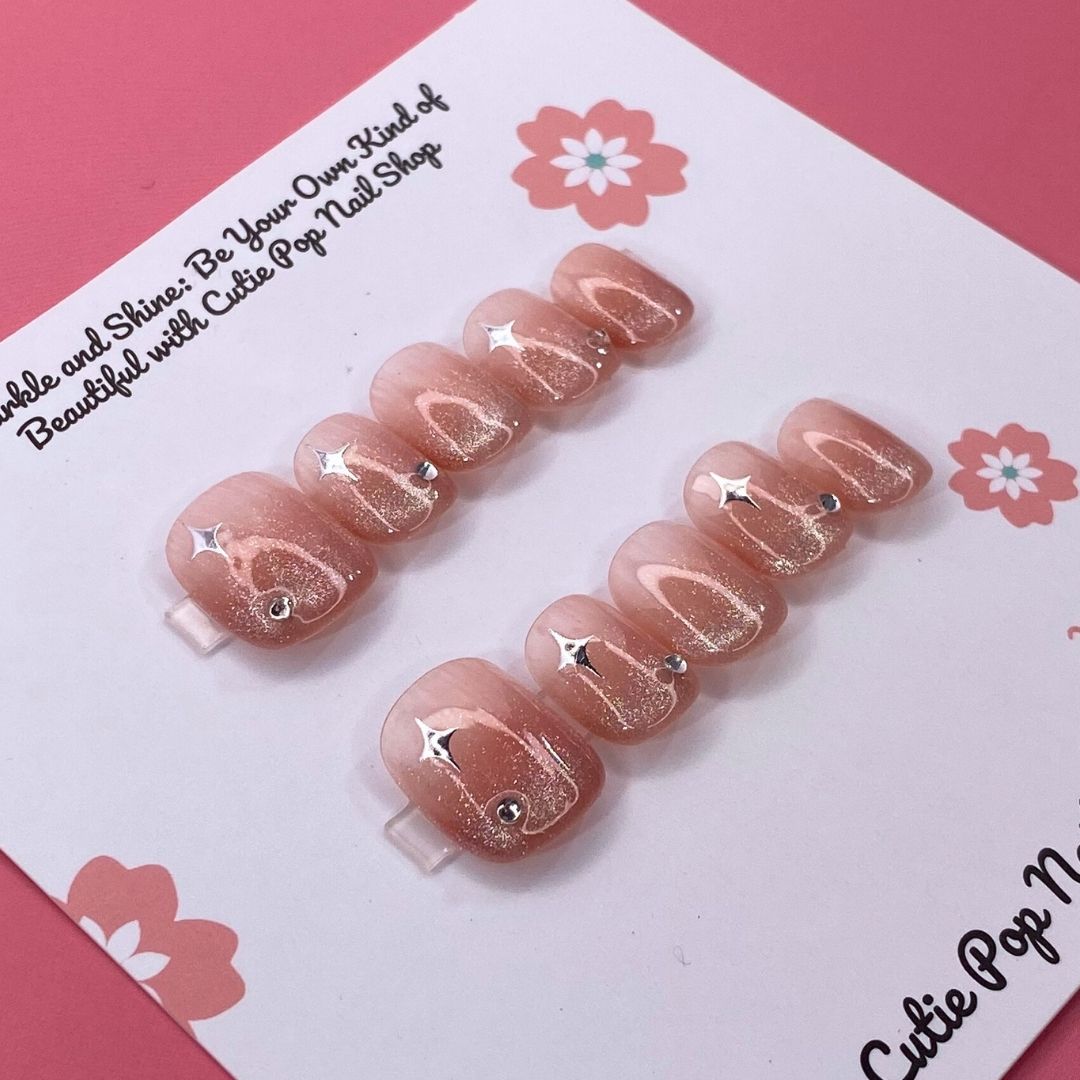 Glittery Blush press on nails by CutiePop Nail Shop featuring short squoval shaped nails in soft blush pink tones with a glittery, shimmering finish for a subtle yet elegant sparkle.
