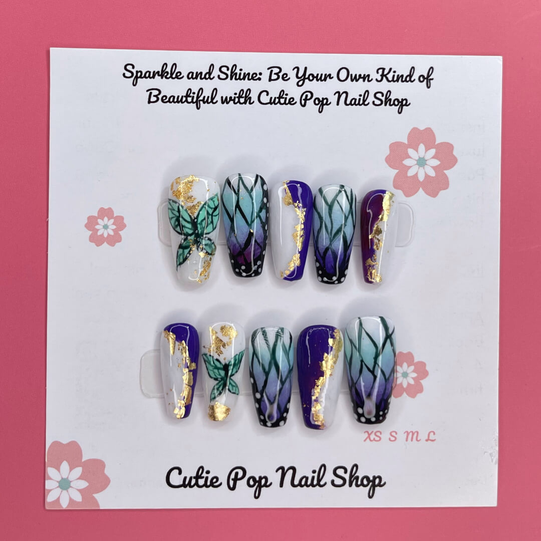Shinobu Butterfly press on nails by CutiePop Nail Shop featuring medium coffin shaped nails in an elegant blend of soft lavender, mint, and pale pink tones. Hand painted butterfly wing patterns inspired by the Demon Slayer Insect Hashira are accented with fine glitter shimmer and delicate metallic veins. Finished with a glossy gel coat for a graceful, ethereal aesthetic.
