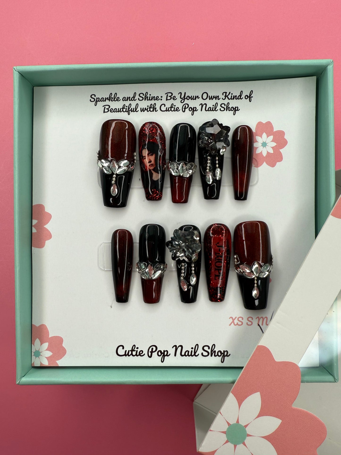 J-Hope BTS Concert-Inspired press-on nails by CutiePop Nail Shop featuring medium-length coffin-shaped nails in bold colors and playful patterns, accented with charms and design elements that reflect J-Hope’s vibrant, energetic stage presence and signature style.