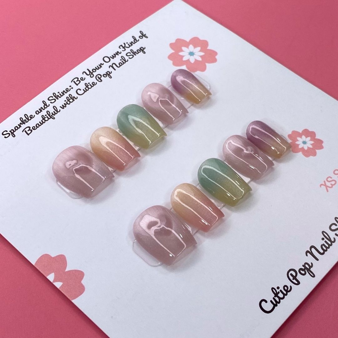 Pastel Holo press-on nails by CutiePop Nail Shop feature extra-short square-shaped nails in soft pastel hues with a mesmerizing holographic finish. This dreamy, iridescent design adds a subtle yet magical glow to your everyday look. Each kit includes 10 reusable handmade nails, jelly adhesive tabs, a mini nail file, and a cuticle stick.