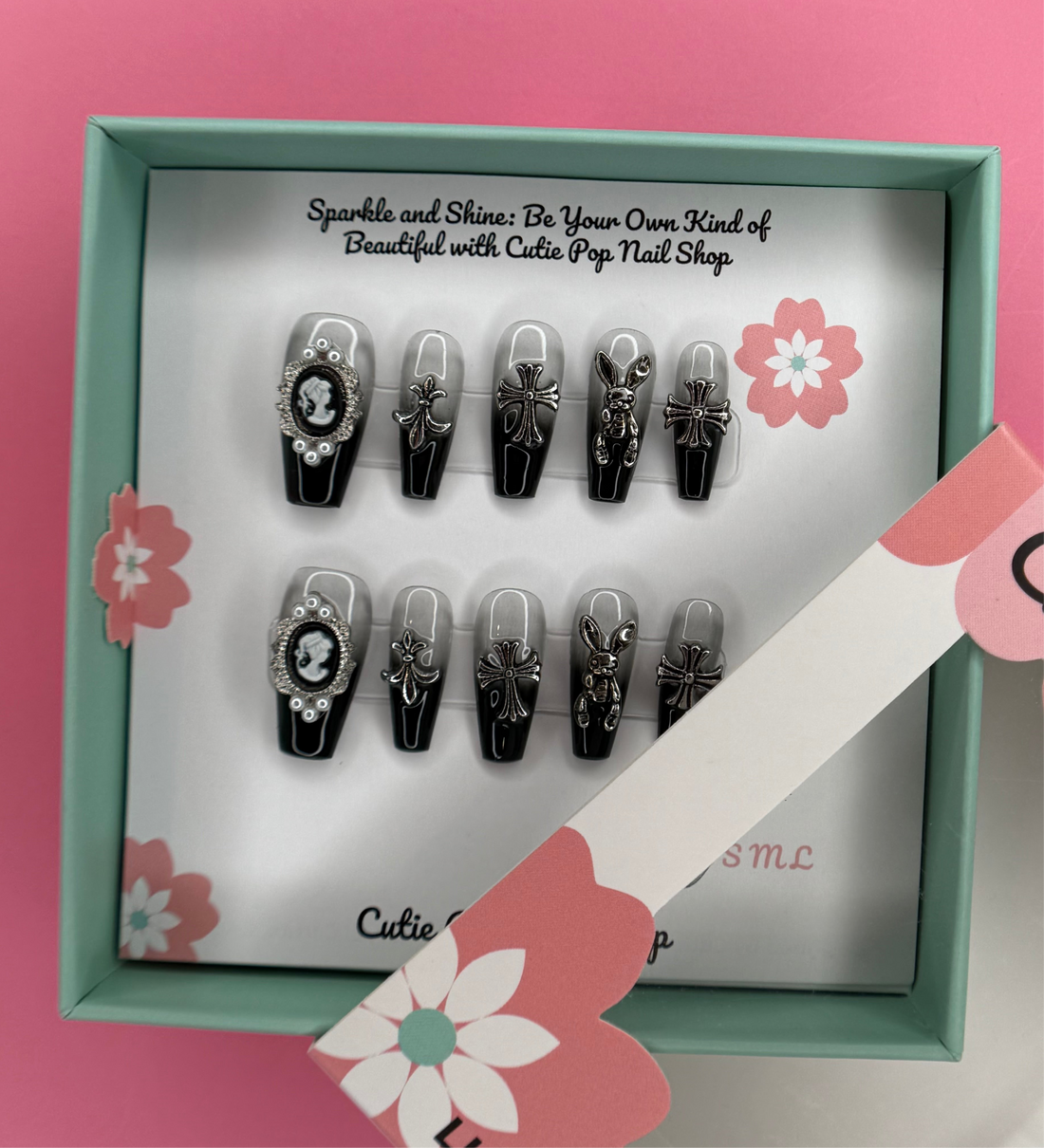 Victorian Ombre press-on nails in a black and silver ombré design with glossy finish, featuring detailed 3D ornaments like a cross, bunny, and decorative charms – displayed on a Cutie Pop Nail Shop card.