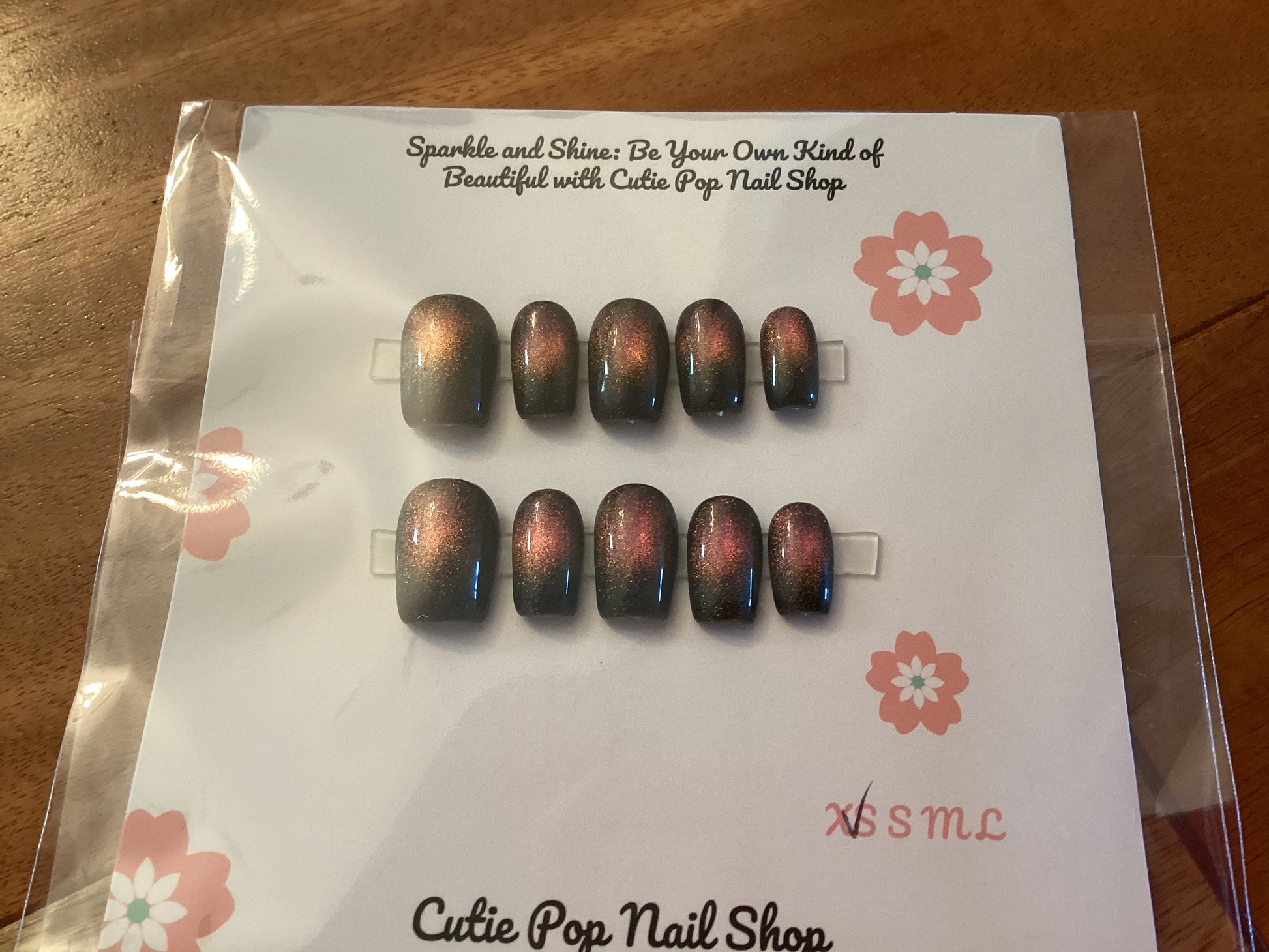 Cat’s Eye Magenta Shift press-on nails in a vibrant magenta shade with a maroon-toned center shimmer and a glossy finish – displayed on a Cutie Pop Nail Shop card.