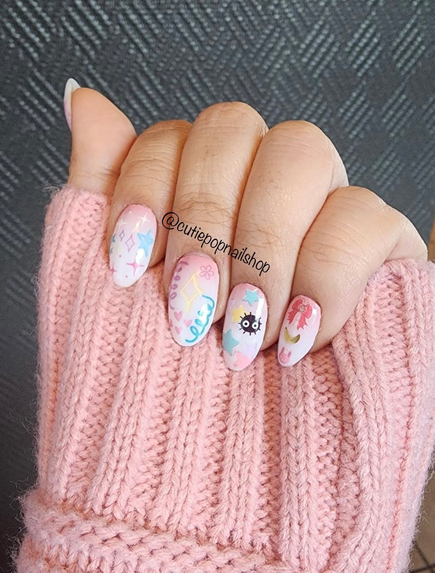 Pastel Eevolution nail stickers by Cutie Pop Nail Shop featuring hand-drawn chibi-style Pokémon designs of Eevee and its evolutions in soft pastel tones, including fire, water, and electric types arranged on a pink edged display card labeled "Easy Peel & Apply Nail Stickers."