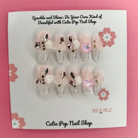 Elegant Rose (Pink) press on nails by CutiePop Nail Shop featuring medium coffin shaped nails in soft pink tones, adorned with delicate rose art and elegant floral accents. Designed for a classy and romantic look, perfect for adding a touch of timeless charm to any outfit.

