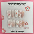 White Ribbon Pink Flower press-on nails by CutiePop Nail Shop featuring medium-length coffin-shaped nails in soft pink tones. Embellished with pearl accents, white ribbon details, and delicate pink floral designs, this set offers a sweet and feminine aesthetic perfect for elegant everyday wear.

