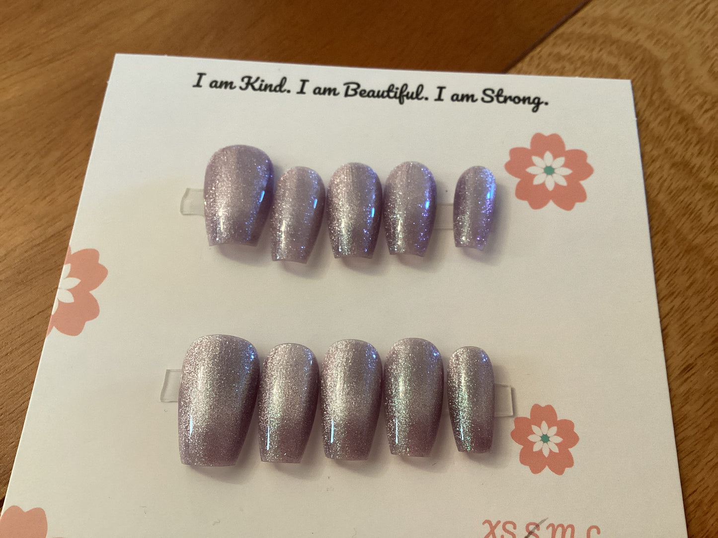 Cat’s Eye Lavender press-on nails in a soft lavender shade with fine glitter and a glossy finish – displayed on a Cutie Pop Nail Shop card