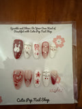 Y2K Red Bunny press-on nails in bold red tones with glossy finish, featuring playful 3D bunny and Y2K-inspired accents – displayed on a Cutie Pop Nail Shop card.