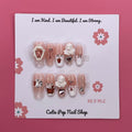 Angelic Bunny press on nails by CutiePop Nail Shop featuring medium coffin shaped nails in soft pastel tones, adorned with bunny charms, angel wings, and pearl or glitter details for a cute and dreamy aesthetic.

