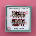 Bougie Bling 13 press on nails by CutiePop Nail Shop featuring long stiletto shaped nails with a rich deep burgundy red or wine toned glitter base. Lavish oversized 3D gem clusters in jewel tones including ruby and crystal are accentuated with sparkling rhinestones and metallic highlights for a dramatic, high end glitzy manicure.