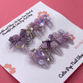 Bougie Bling 16 press-on nails by CutiePop Nail Shop feature medium-length almond-shaped nails in a shimmering lavender-purple glitter base, adorned with ornate 3D gem clusters and delicate rhinestone accents. Each nail is meticulously hand-sculpted to create a luxurious, playful-glam statement manicure. Includes 10 reusable nails, jelly adhesive tabs, a mini nail file, and a cuticle stick.

