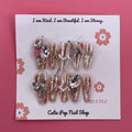 Bougie Bling 19 press on nails by CutiePop Nail Shop showcasing long coffin shaped nails with a luxe metallic rose gold base, oversized 3D gem clusters, sparkling rhinestone accents, and hand sculpted detailing—offering a glamorous, high end aesthetic.

