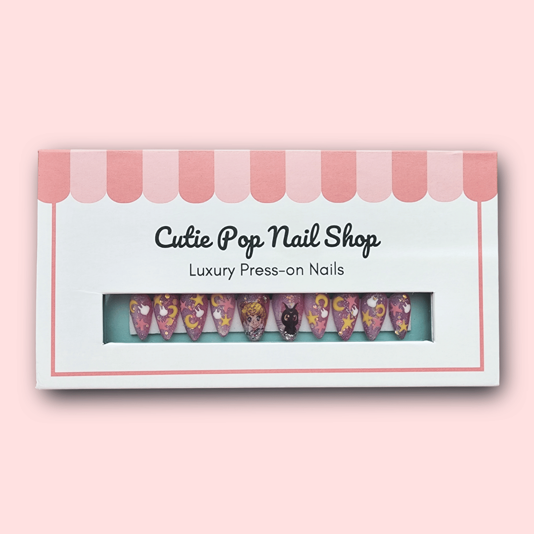 Kawaii Moon press‑on nails showcasing short- to medium-length almond-shaped or round nails in a soft pastel pink and lavender jelly base. Accented with hand-painted or high-detail 2D moon decals, iridescent star sequin glitter, and tiny metallic foil moons. Each nail glimmers in a dreamy glow—designed for a magical, kawaii-inspired manicure. (Kit includes ten reusable nails, adhesive tabs, a mini nail file, and cuticle stick.