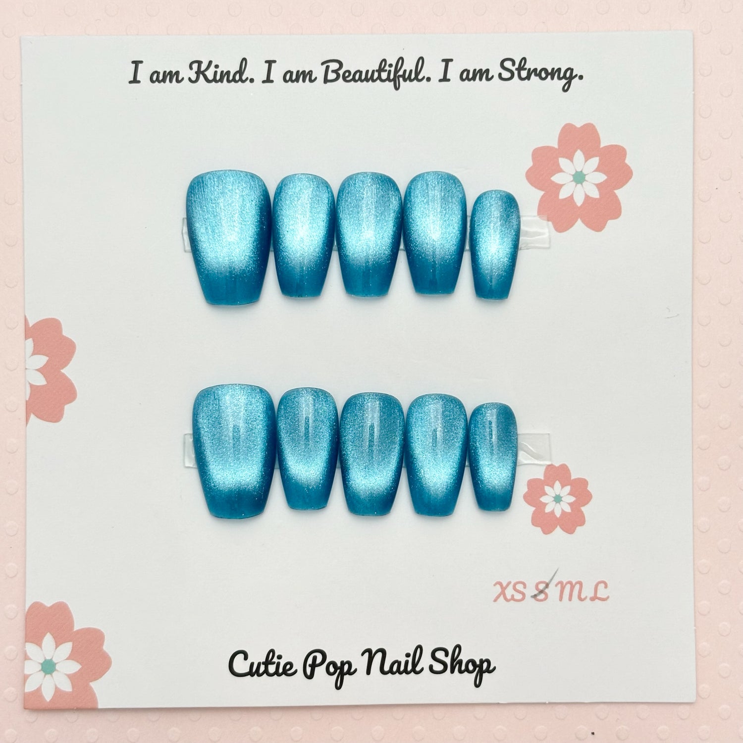 Set of blue aqua presson nails on Cutie Pop Nail Shop branded card with motivational quote and floral designs.ua