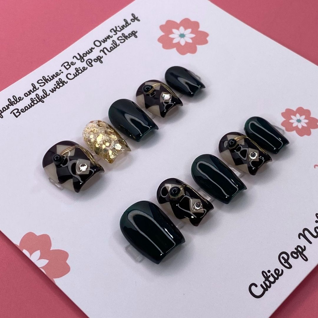 Classy Harlequinn press on nails by CutiePop Nail Shop featuring short squoval shaped nails with a sophisticated harlequin diamond pattern in black and white, accented with gold studs and a glossy finish—offering an elegant, timeless twist on a classic design.

