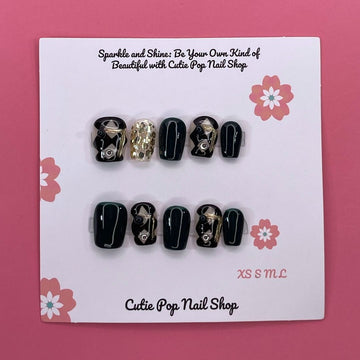 Classy Harlequinn press on nails by CutiePop Nail Shop featuring short squoval shaped nails with a sophisticated harlequin diamond pattern in black and white, accented with gold studs and a glossy finish—offering an elegant, timeless twist on a classic design.

