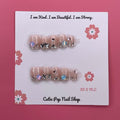 Cutesy Star press on nails by CutiePop Nail Shop featuring short squoval shaped nails in soft pastel pink and lavender tones, adorned with cute star, heart, and pearl accents for a dreamy kawaii look.

