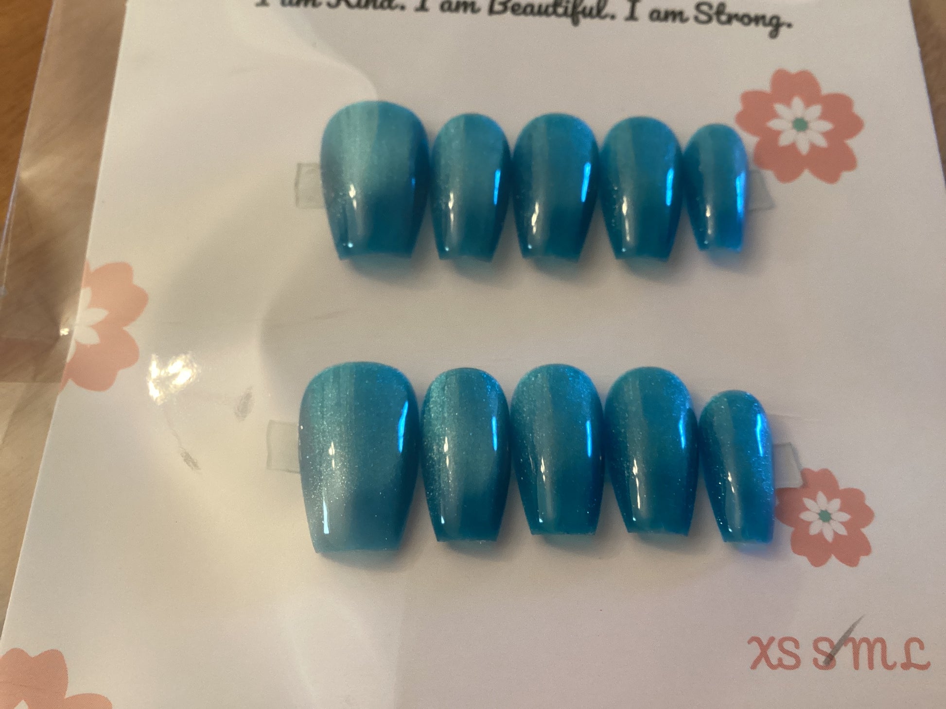 Cat’s Eye Aqua press-on nails in a vibrant aqua blue shade with a glossy finish – displayed on a Cutie Pop Nail Shop card