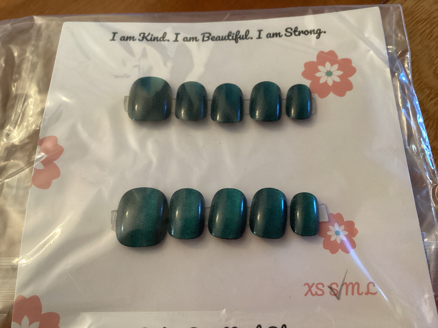 Cat’s Eye Neptune press-on nails in a deep teal blue shade with a glossy finish – displayed on a Cutie Pop Nail Shop card.