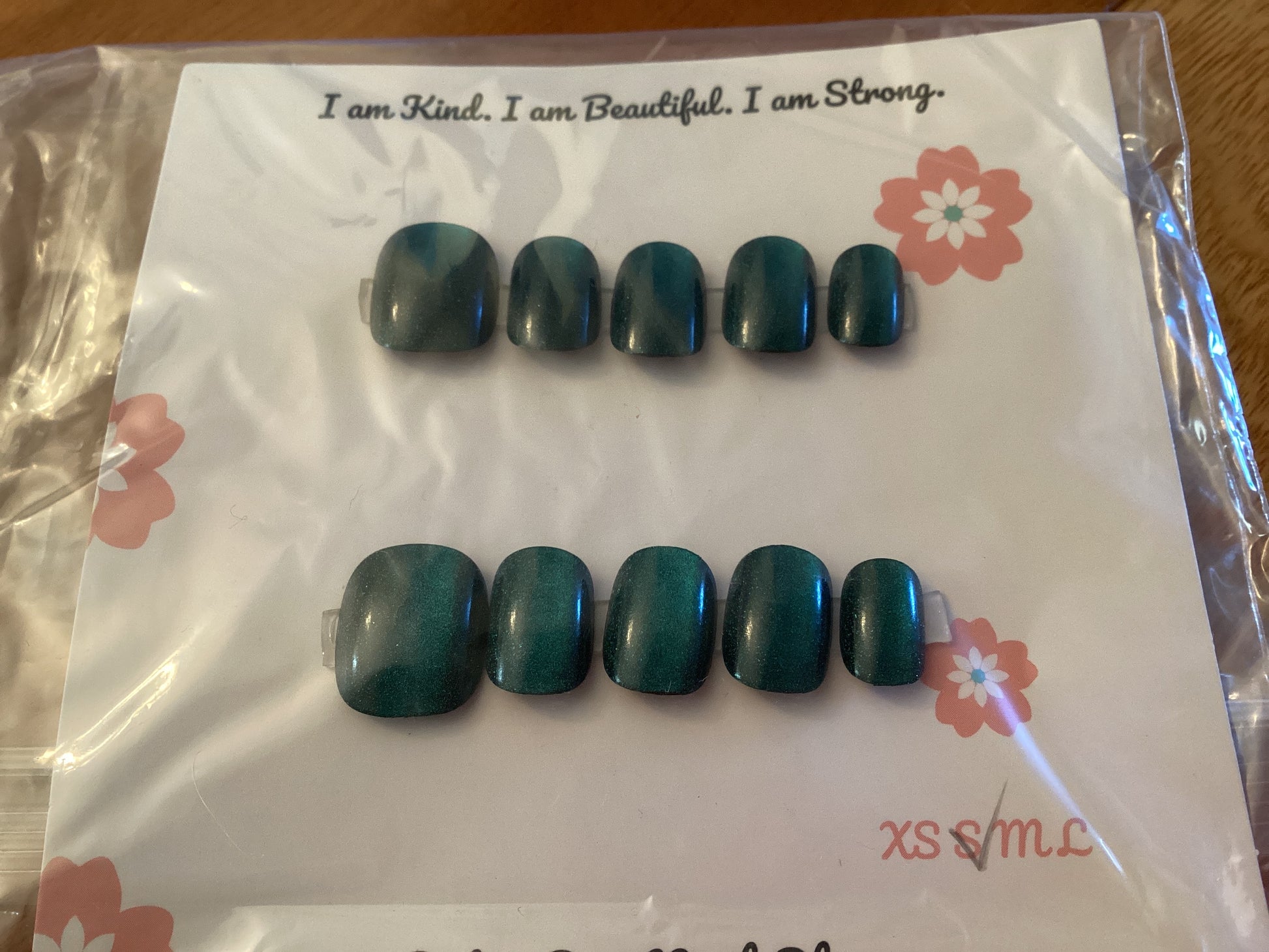 Cat’s Eye Neptune press-on nails in a deep teal blue shade with a glossy finish – displayed on a Cutie Pop Nail Shop card.