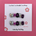 Galaxy Beauty press-on nails by CutiePop Nail Shop featuring extra short squoval-shaped nails in a cosmic blend of deep blue, purple, and black tones, accented with shimmering stars, moons, and glitter for a bold celestial look.


