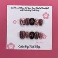 Glittered Heart press-on nails by CutiePop Nail Shop featuring short square-shaped nails in soft pink or nude tones, adorned with glitter accents and heart-shaped charms for a sweet and romantic finish.

