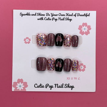 Glittered Heart press-on nails by CutiePop Nail Shop featuring short square-shaped nails in soft pink or nude tones, adorned with glitter accents and heart-shaped charms for a sweet and romantic finish.

