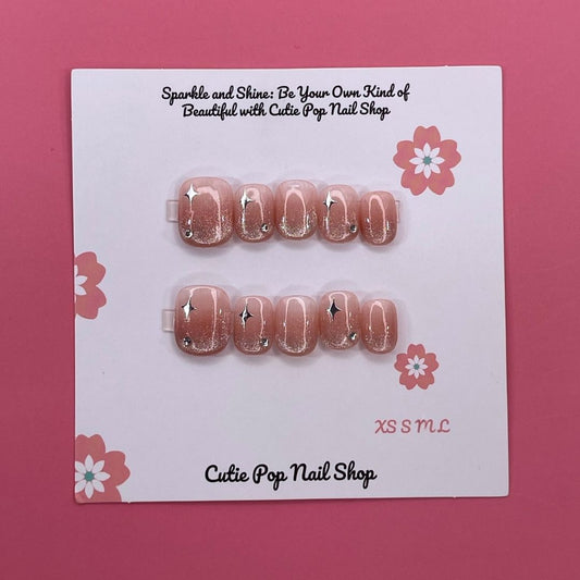 Glittery Blush press on nails by CutiePop Nail Shop featuring short squoval shaped nails in soft blush pink tones with a glittery, shimmering finish for a subtle yet elegant sparkle.