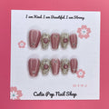 Gold Rosey press on nails by CutiePop Nail Shop featuring medium coffin shaped nails in a luxurious mix of rose gold and warm golden hues, enhanced with hand sculpted 3D gel accents and subtle metallic shimmer for an elegant and glamorous aesthetic.

