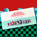 Slayer Nails press-on nails by CutiePop Nail Shop featuring medium-length round-shaped nails adorned with anime-inspired chibi character decals from the Demon Slayer universe. Each custom set is handcrafted and sized to fit your natural nails. Includes 10 reusable gel nails, jelly adhesive tabs, a mini nail file, and a cuticle stick. Perfect for fans of kawaii anime aesthetics and curated cosplay looks.

