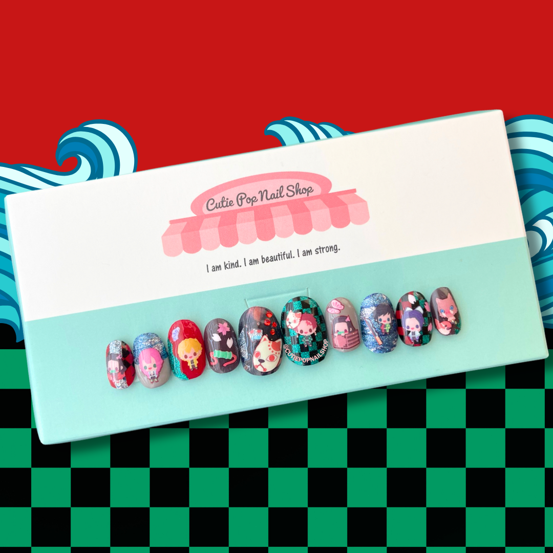 demon slayer inspired press-on nails. brightly colored short round fake nails with chibi demon slayer inspired characters over red, green abd black checkered, and grey and glitter nails