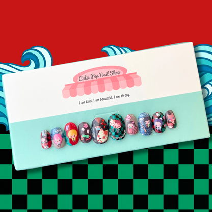 demon slayer inspired press-on nails. brightly colored short round fake nails with chibi demon slayer inspired characters over red, green abd black checkered, and grey and glitter nails