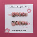 Peach Princess press on nails by CutiePop Nail Shop featuring short squoval shaped nails in soft peach tones with floral details, pearls, and subtle glitter for a sweet and elegant princess-inspired look.


