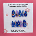 Digipet Evolution press on nails by CutiePop Nail Shop featuring medium almond shaped nails with a glossy royal blue and purple gradient, hand painted with nostalgic anime-style Digipet character silhouettes and sparkly star accents. Includes an easy press on reusable set: adhesive tabs, mini nail file, and cuticle stick.

