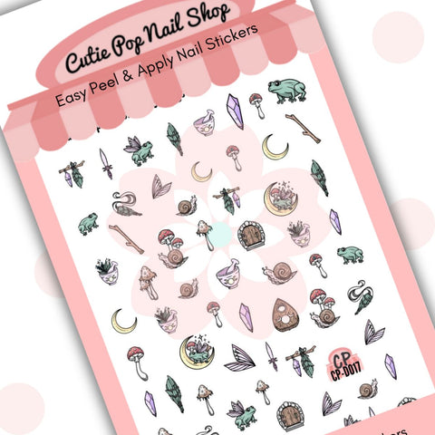 This image showcases Cutie Pop Nail Shop’s Cottage Core nail decals against a white background with a Cutie Pop Nail Shop logo and watermark. These back-to-nature-style nail decals designs include mushrooms, toadstools, frogs, frogs with wings, lilac gemstones, chrysalises, twigs, snails, wings, pestle-and-mortars with herbs, crescent moons, wooden doorways, and swords.