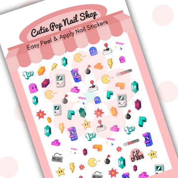 RetroGamer nail stickers by Cutie Pop Nail Shop featuring ultra thin 2D designs inspired by classic arcade and console games, including block puzzles, power up stars, vintage controllers, handheld devices, and health bars arranged on a pink edged display card labeled "Easy Peel & Apply Nail Stickers."