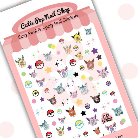Cutie Pop Nail Shop’s Digipet Eevolution nail decals. These nail decals feature a range of multicolor pocket-monster-style handheld gaming devices. Colors include blue, orange, white, pink, black, and yellow. Each design is different, with one being furry, another having a leaf design, another having wings, and another having webbed features. There are also a range of multicolor star designs as well as multicolored pocket monster balls.